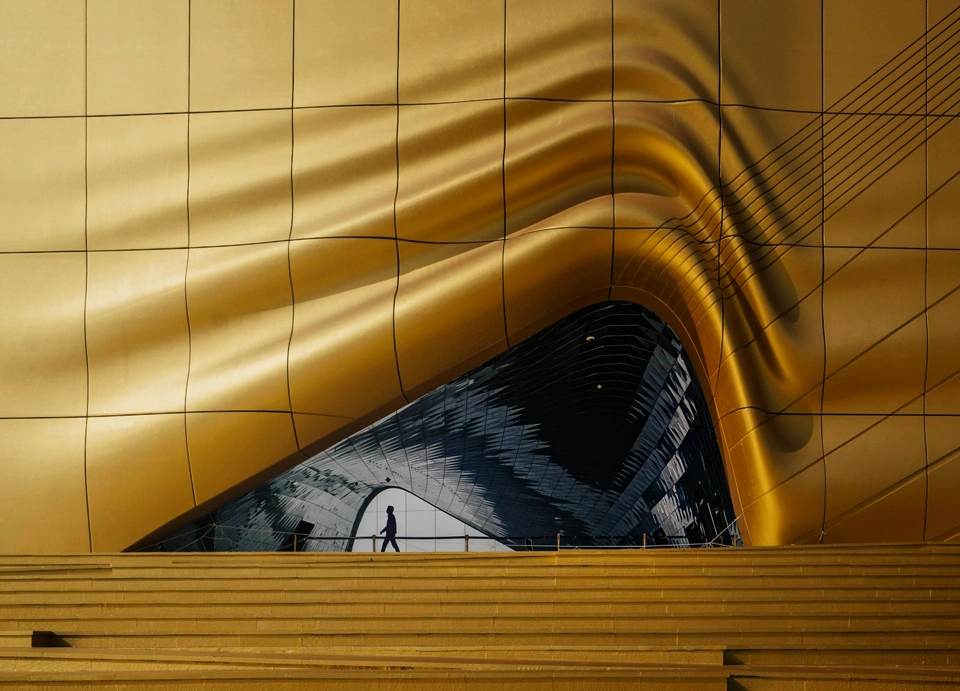 Edificio moderno con facciata dorata e silhouette umana, simbolo di innovazione nel settore farmaceutico.