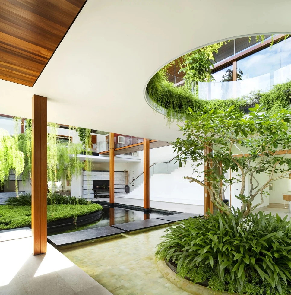 Ambiente moderno con giardino interno e ampia luce naturale, ideale per spazi aziendali farmaceutici eco-friendly.