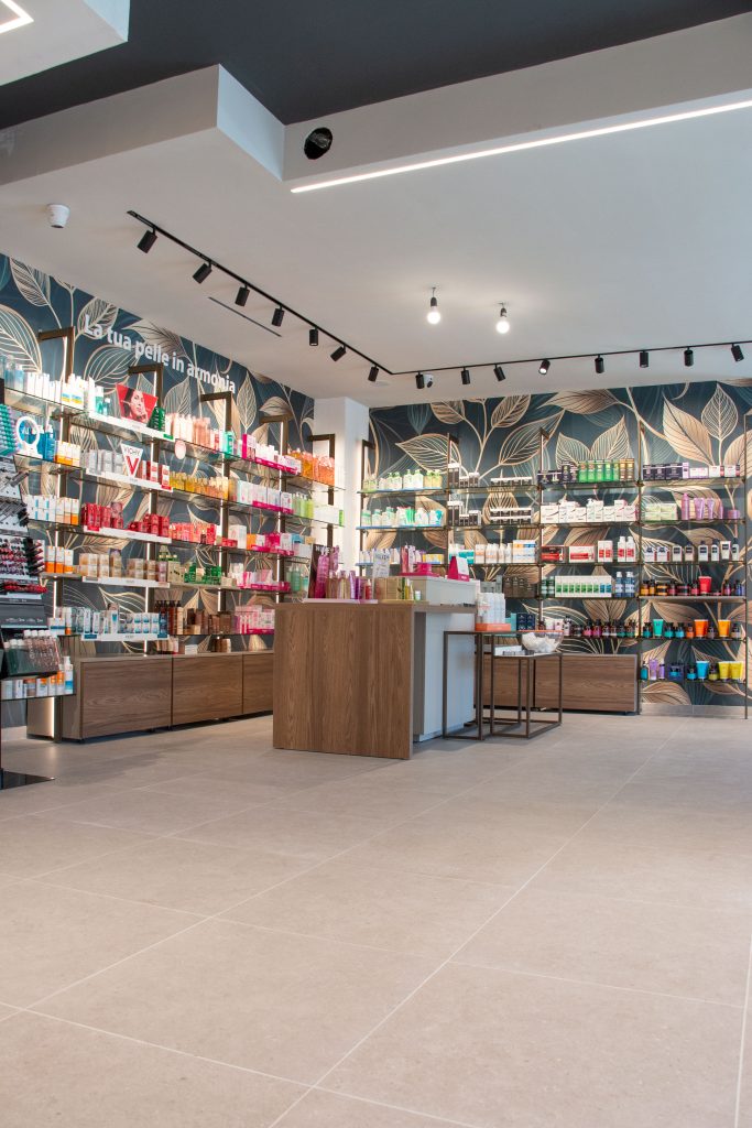 Modern pharmacy interior showcasing a variety of skincare products on shelves, with a stylish checkout counter.
